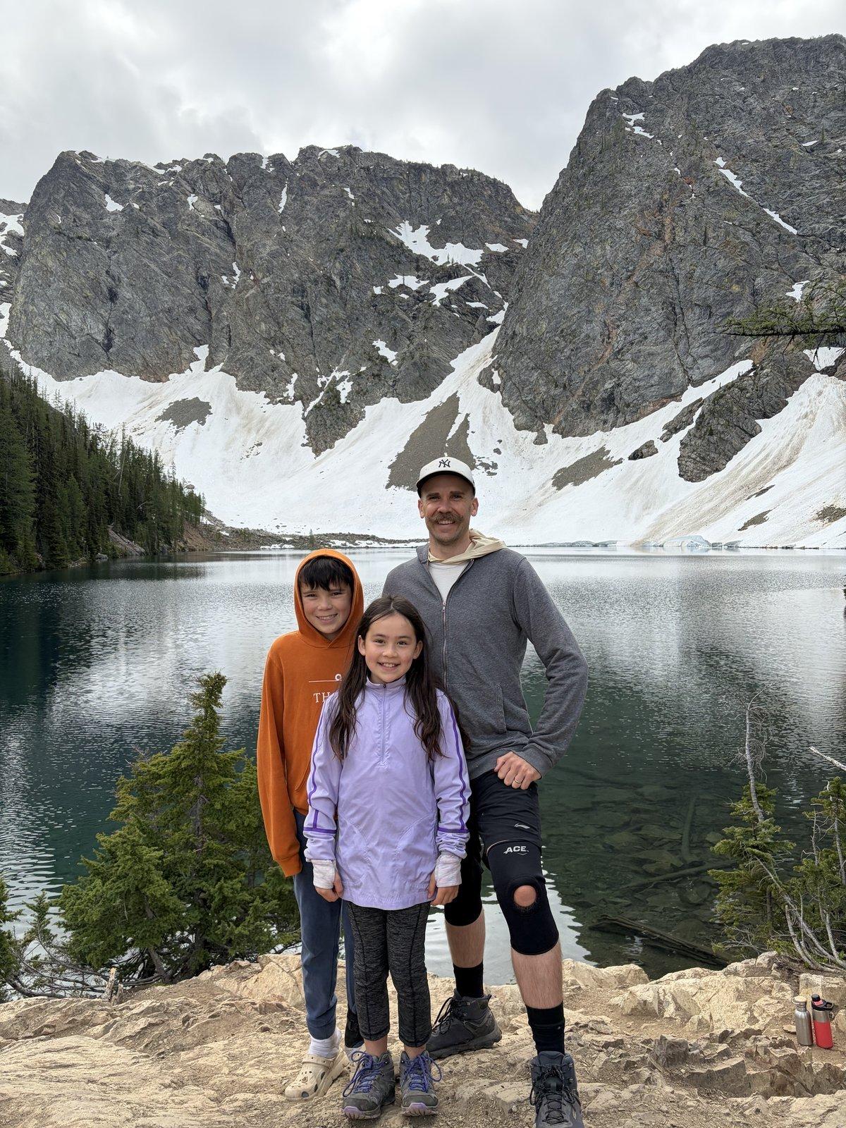 North Cascades — the family at an alpine lake below the snow.