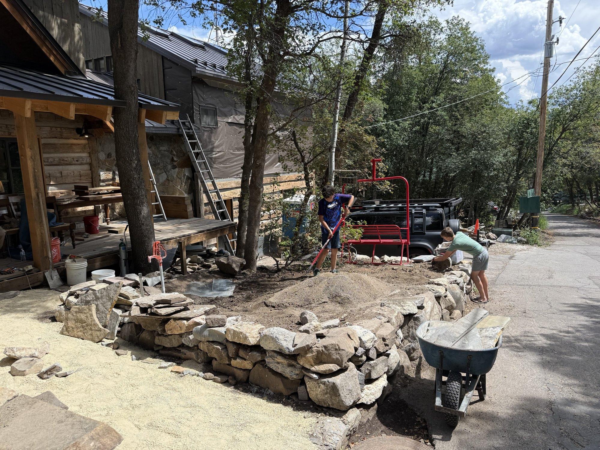 Lincoln working on a stone retaining wall.