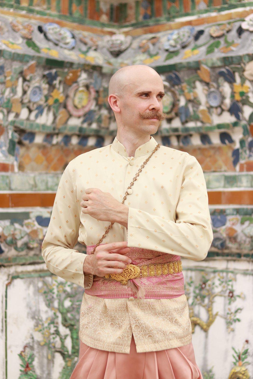 Jordan in traditional Thai wedding attire at a temple in Bangkok.